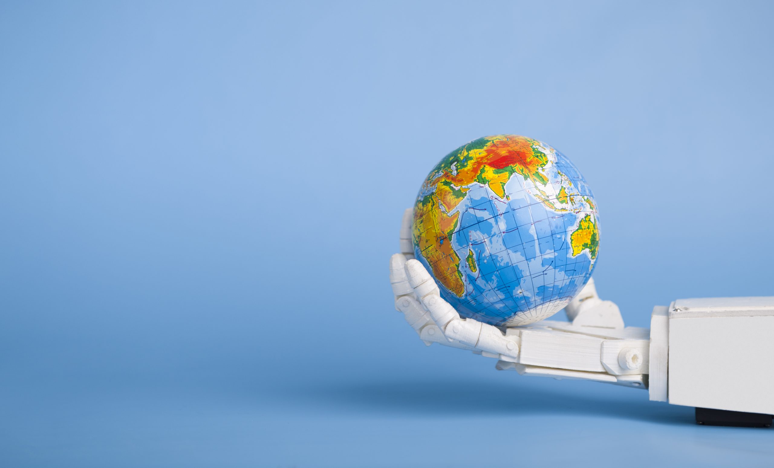 Global automatization concept. Earth globe in robotic hand, blue panorama background with copy space